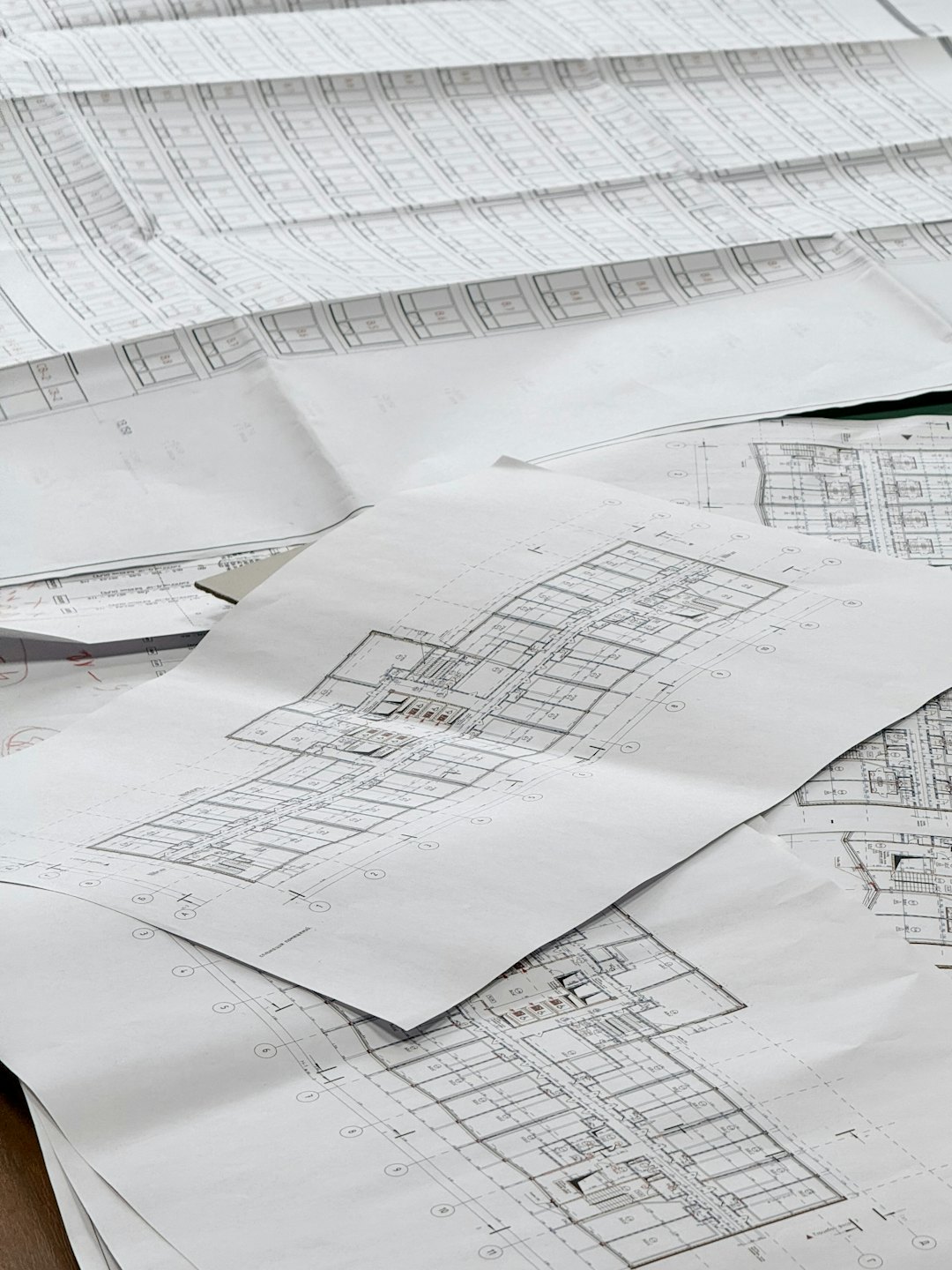 Architectural blueprints and floor plans spread on a flat surface.